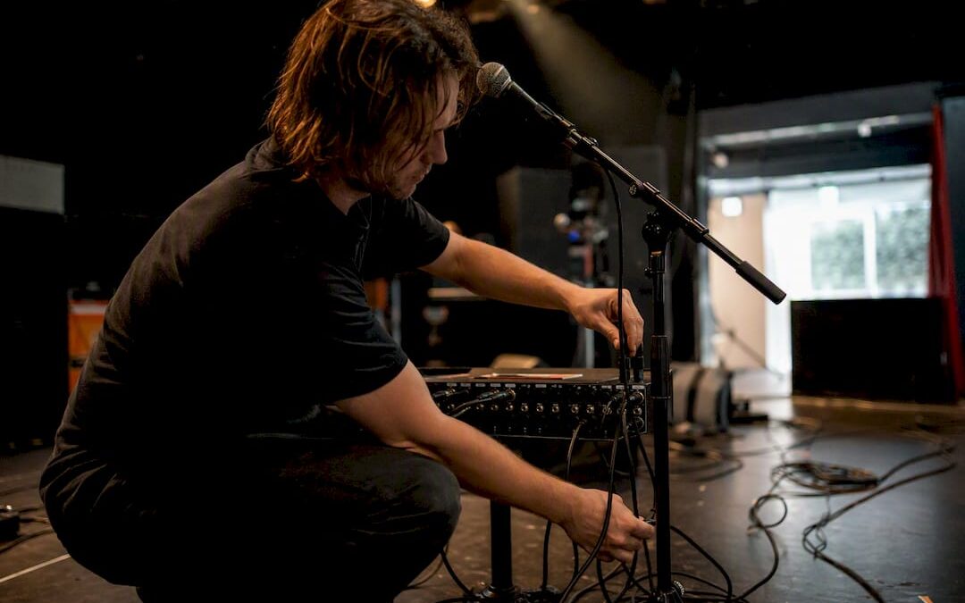 Hands adjusting stage microphone cables